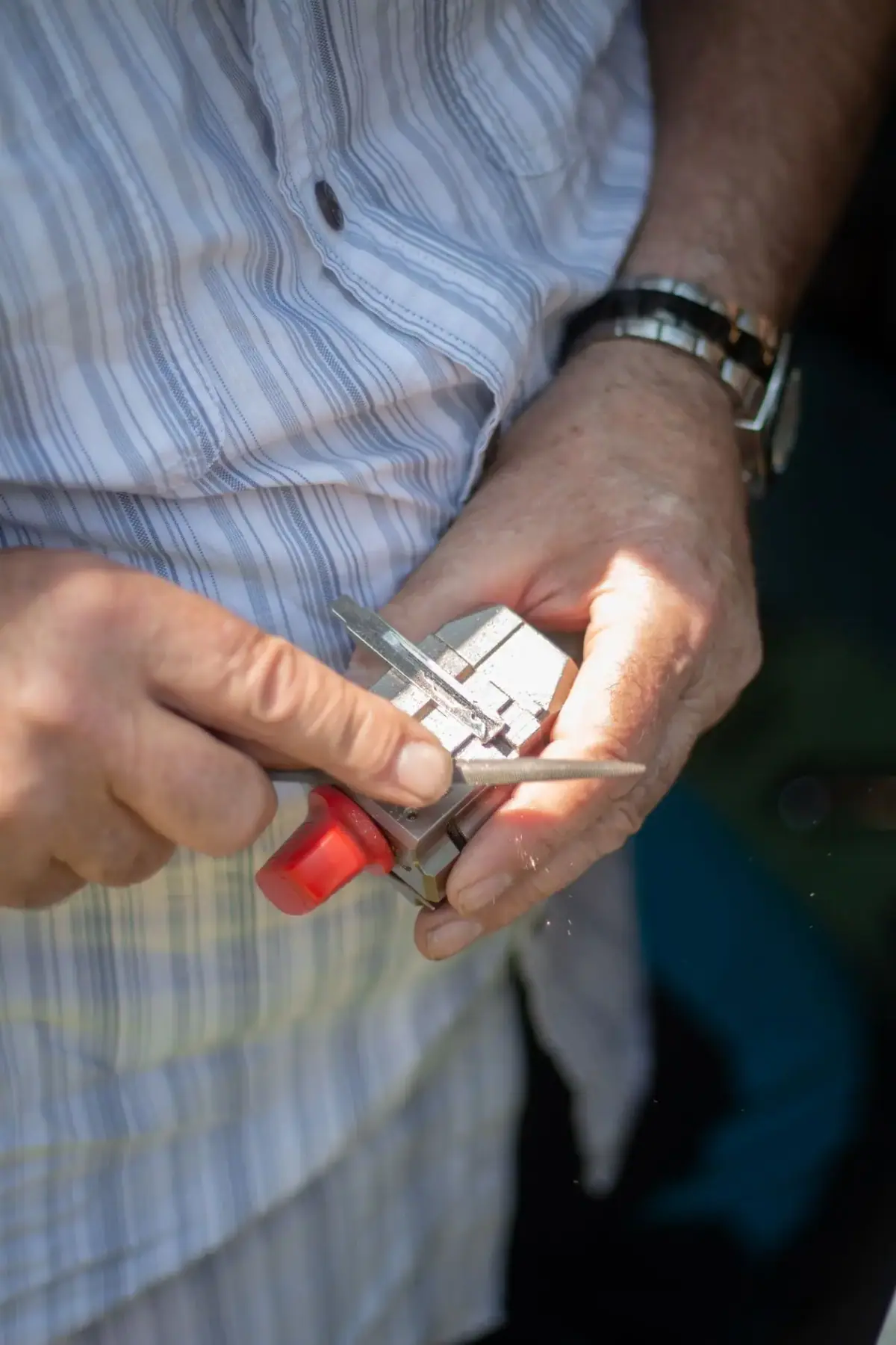 Locksmith cutting a new car key in Costa Mesa