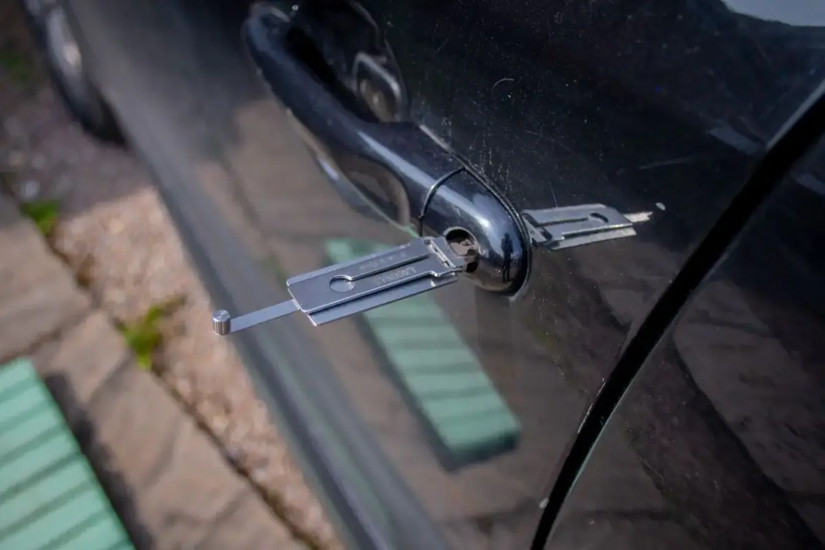 Locksmith opening a car door with a professional entry tool in Costa Mesa